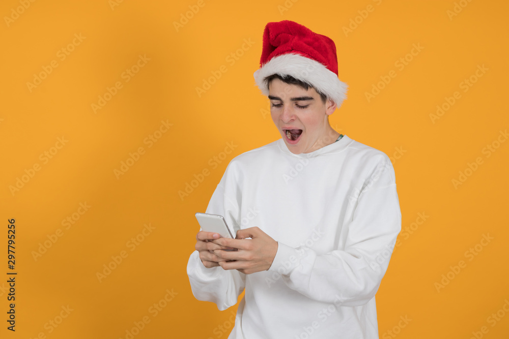 young teenage man with santa claus hat isolated on color background
