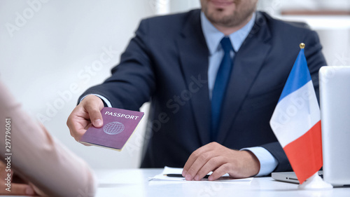 French consular officer giving passport to woman, refugee visa, asylum status photo