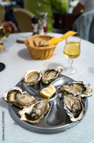 close up of delicious fresh oysters on the half shell with a glass of French white wine