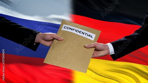Tableau sur toile Russia and Germany officials exchanging confidential envelope, flags background