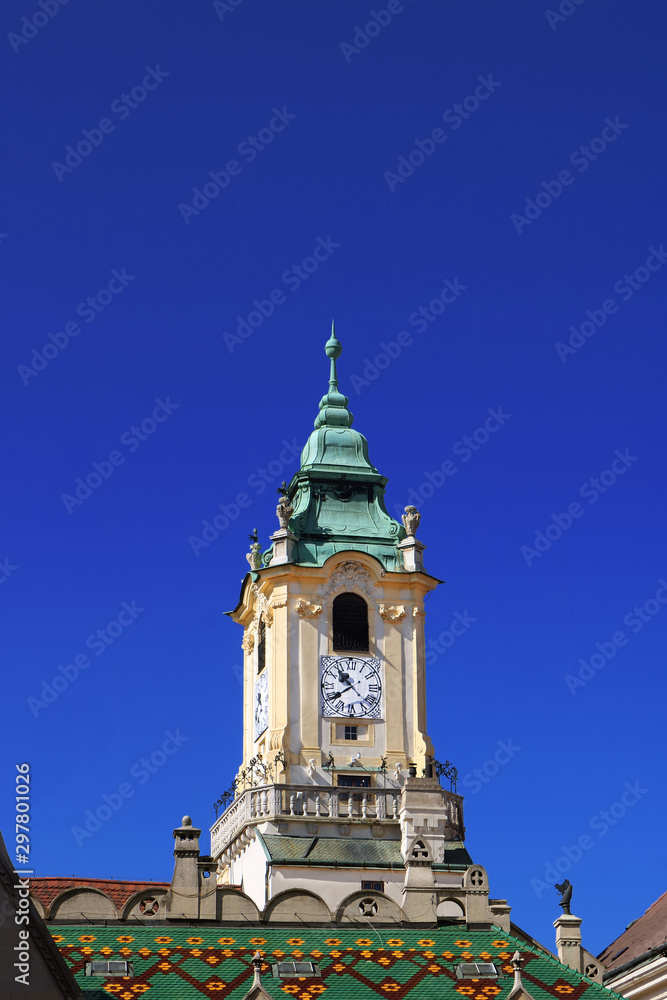 Top view of old town hall with decorated green and yellow roof. View from Primates Square in the old town of Bratislava, Slovakia