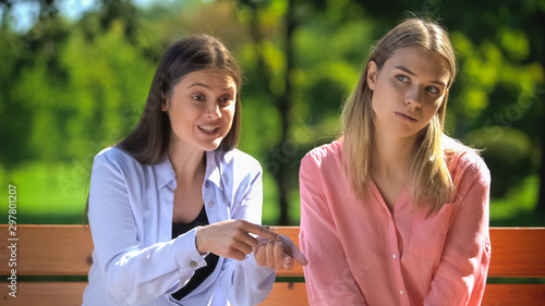 Foto Tired female listening to annoying friend sitting outdoors, envy, selfishness