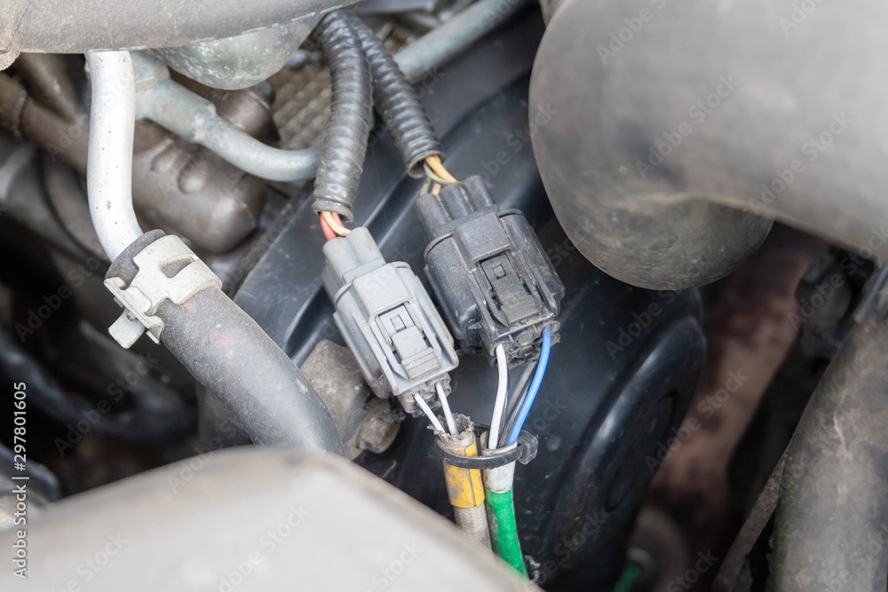 Fototapeta premium Wires under the open hood of a car engine. Car diagnostics and repair at a service station