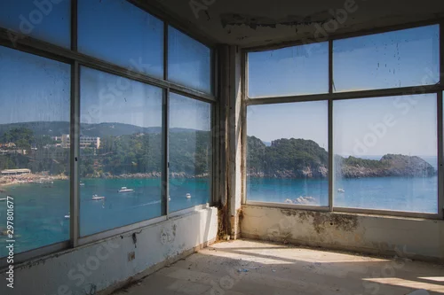 Fototapeta Duże okno opuszczonego hotelu z widokiem na zatokę oceaniczną