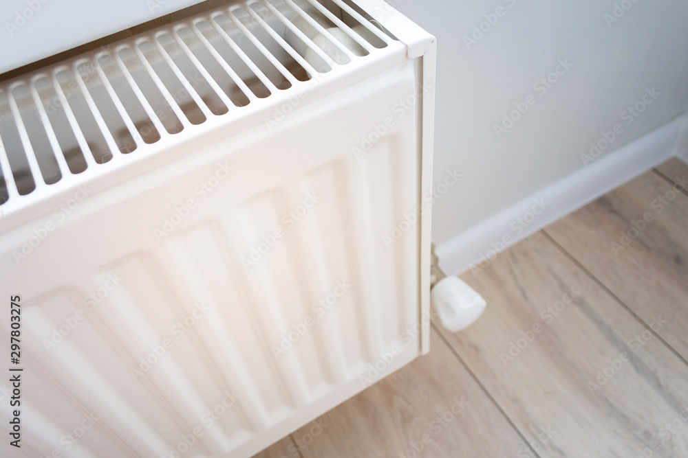 custom made wallpaper toronto digitalCloseup view of a home heating radiator in a living room with wooden floor and light wall. Creating and keeping a comfortable temperature in the house in the winter. Visual heat radiation
