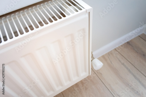 Wallpaper Mural Closeup view of a home heating radiator in a living room with wooden floor and light wall. Creating and keeping a comfortable temperature in the house in the winter. Visual heat radiation Torontodigital.ca