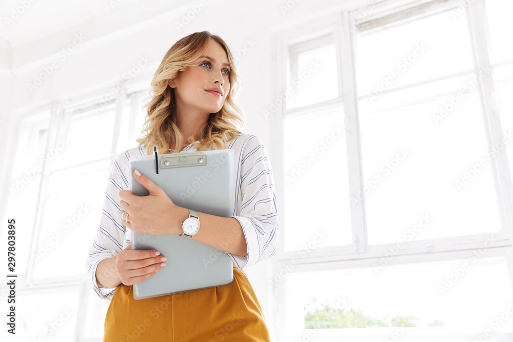 Image of successful elegant secretary woman holding clipboard in office Image of successful elegant secretary woman holding clipboard in office