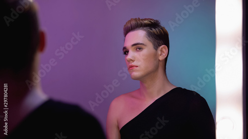 Konstfotografi Genderqueer with half-face makeup looking in mirror, non-binary identity concept