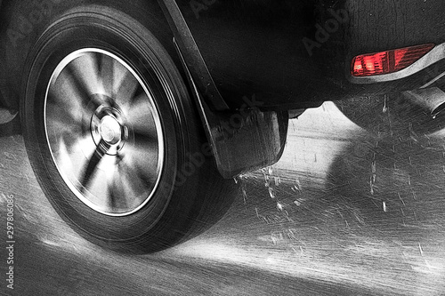Tableau sur toile The Detail of the rear wheel of a car driving in the rain on a wet road