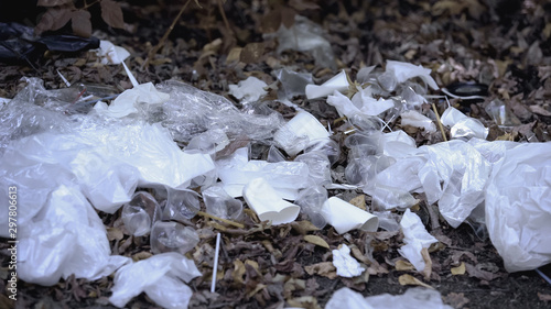 Plastic bag lying among litter landfill in forest, global ecological problem