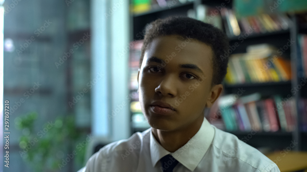 Upset tired black student in uniform sighing and sadly looking on cam, laziness Upset tired black student in uniform sighing and sadly looking on cam, laziness
