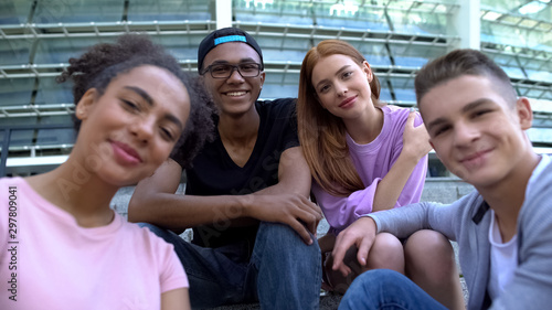 Group of multiethnic teenagers smiling on camera outdoors, friendship connection