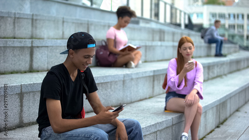 Black university student scrolling smartphone  social networks  gadget addiction