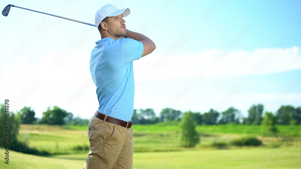Experienced golf player performing swing hitting ball at course, luxury hobby Experienced golf player performing swing hitting ball at course, luxury hobby