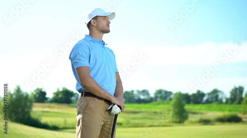 Inexperienced golf player with club in hands upset with failed shot, loser