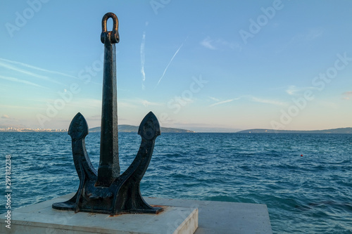 Big steel anchor on the land and the sea in the background. copy space.