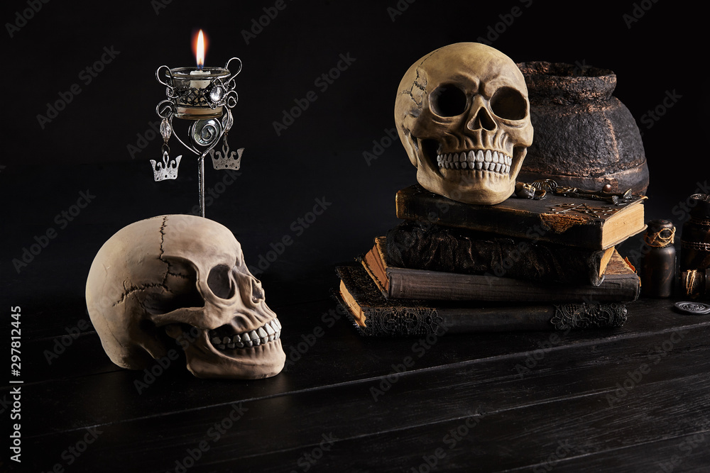 Realistic model of a human skull with teeth on a wooden dark table, black background. Medical science or Halloween horror concept. Close-up shot. Realistic model of a human skull with teeth on a wooden dark table, black background. Medical science or Halloween horror concept. Close-up shot.