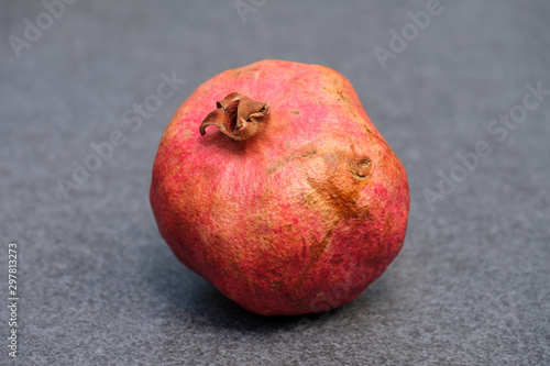 Granatapfel mittig auf grauem Grund