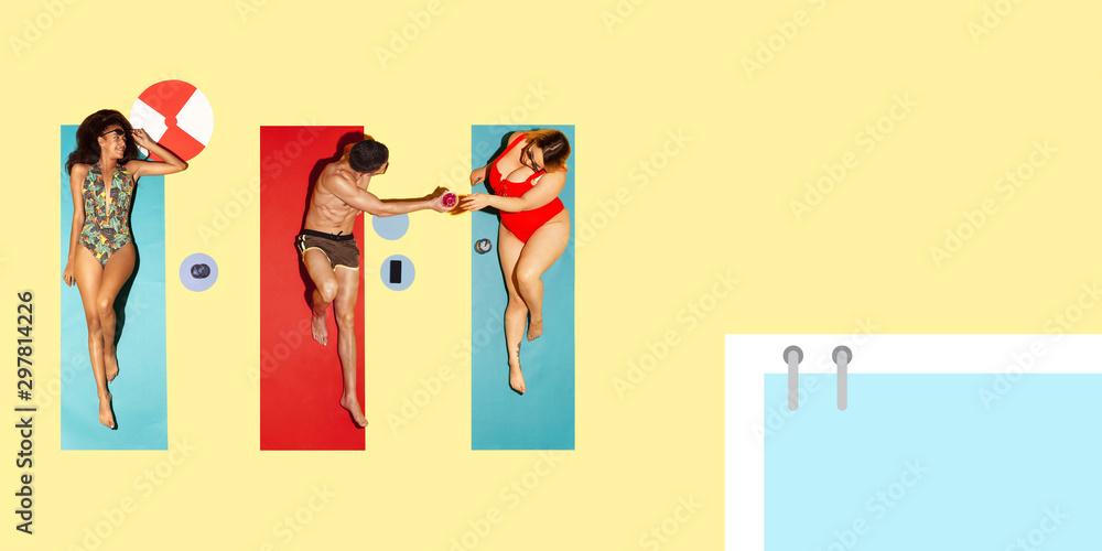 Top view of young caucasian model's resting on beach resort on blue and yellow background as an ocean and sand in bright swimsuit. Copyspace. Concept of summertime, party, chill, vacation, friendship