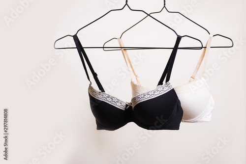 Stylish lingerie. Variety of bra hanging on a hanger. Set of female underwear. Advertise or sale concept photo