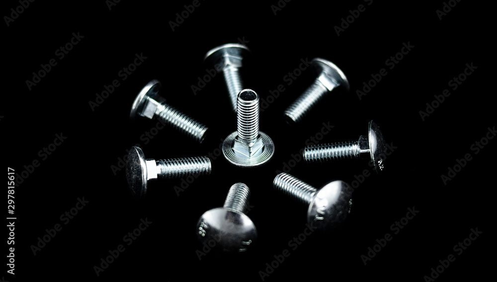 Group of bright screws arranged in a circular and concentric shape on a black background Group of bright screws arranged in a circular and concentric shape on a black background