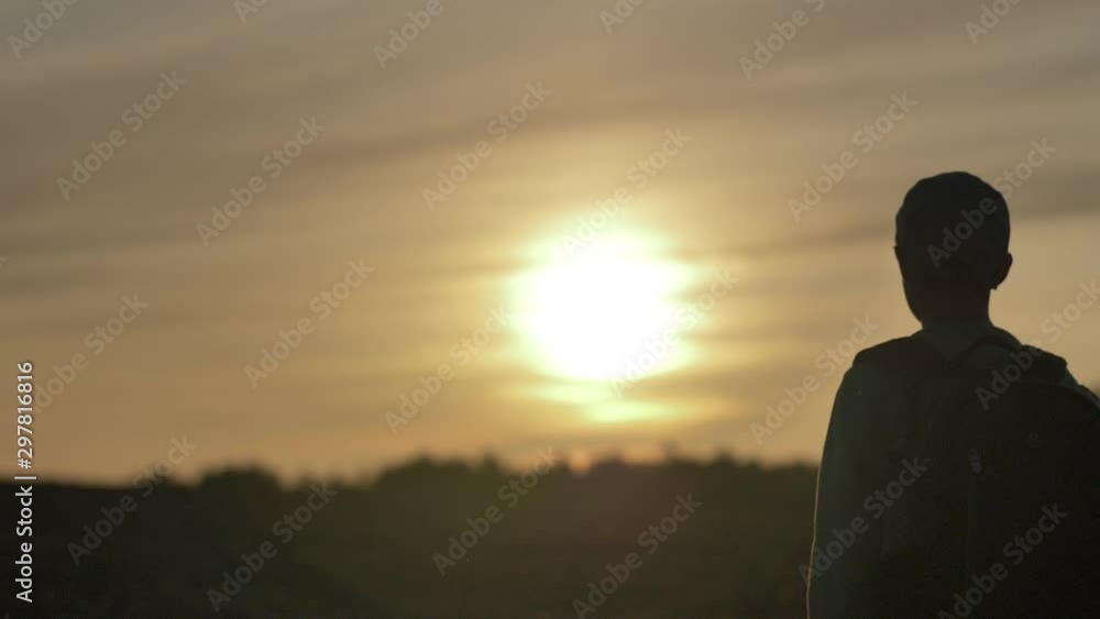 silhouette of a boy with backpack walking at sunset outdoors, travel concept silhouette of a boy with backpack walking at sunset outdoors, travel concept
