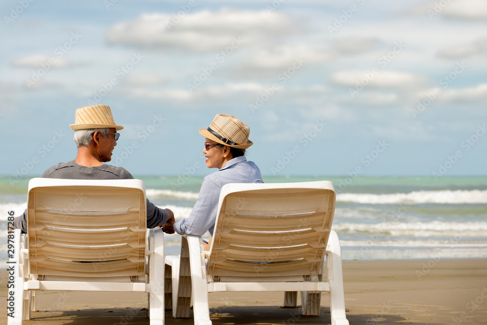 Relax  asian senior couple  sitting on beach chair have fun and enjoy at the beach