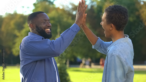 Cheerful black brothers giving high five outdoors  happy family  close relations