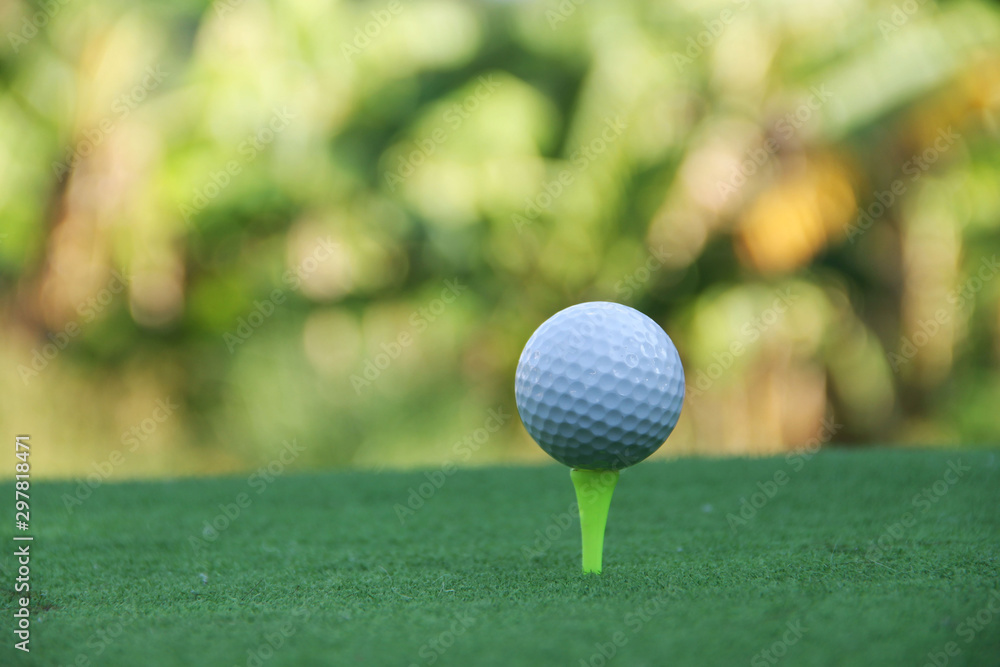 Golf ball on tee in beautiful golf course Golf ball on tee in beautiful golf course
