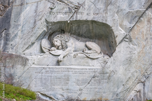 Luzern dying lion monument on the stone cliff with the pond in the foreground in Luzern, Switzerland.