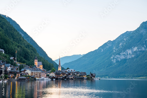 Scenic view of famous Hallstatt lakeside town reflecting in Hallstattersee lake in the Austrian Alps on a sunny day in summer, Salzkammergut region, Austria