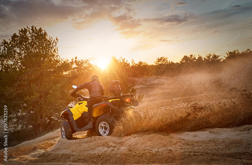 Fototapeta premium Racing powerful quad bike on the difficult sand in the summer.