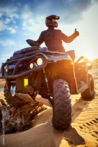 Racing powerful quad bike on the difficult sand in the summer. photo