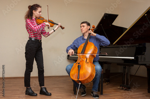 Musicians of the symphony orchestra. Young violinist and cellist in concert costumes.