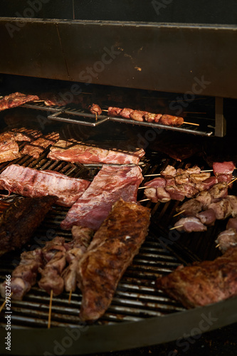 Pork ribs and kebabs grilled on a round grill