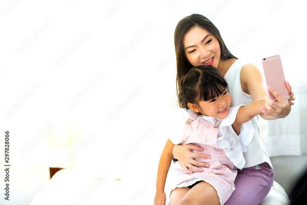 beautiful mother and her daughter making a selfie using smart phone and smiling beautiful mother and her daughter making a selfie using smart phone and smiling