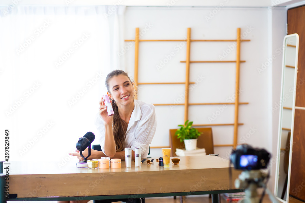 Oner business sme concept. Young female blogger with makeup cosmetics recording video at home Oner business sme concept. Young female blogger with makeup cosmetics recording video at home