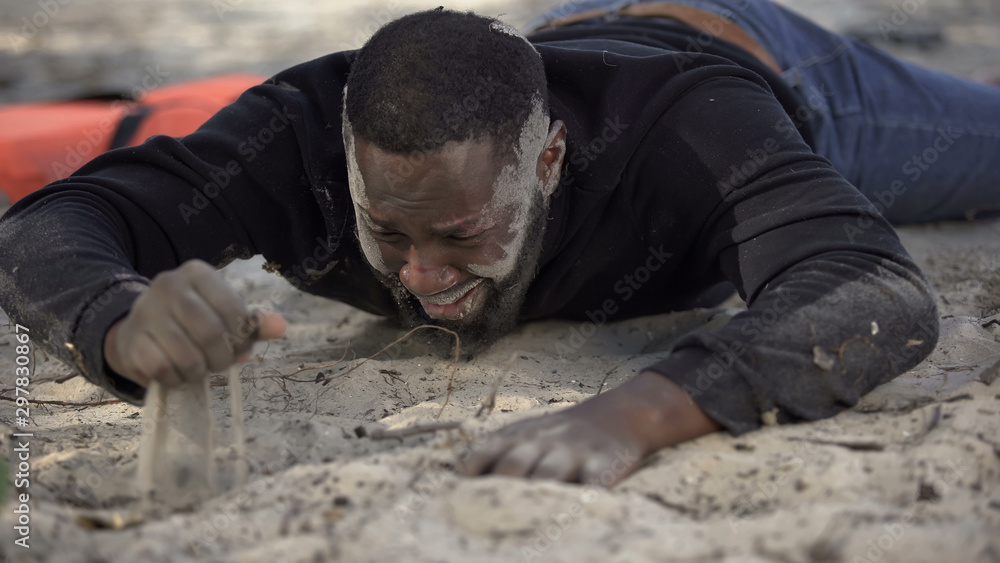 Male refugee with muddy face crying, survived shipwreck, illegal border crossing Male refugee with muddy face crying, survived shipwreck, illegal border crossing
