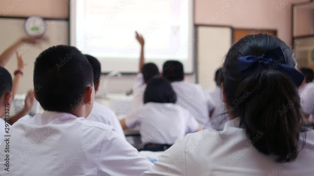 Asian classroom teaching of high school students in white uniform are actively studying science by raising their hands to answer questions that teachers ask them. Asian classroom teaching of high school students in white uniform are actively studying science by raising their hands to answer questions that teachers ask them.