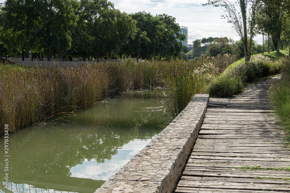 Beautiful green urban park. Public park with green grass fields, trees, waterways and pond. Parque de Cabecera, Valencia, Spain Beautiful green urban park. Public park with green grass fields, trees, waterways and pond. Parque de Cabecera, Valencia, Spain