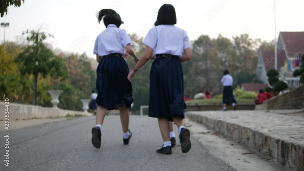 High school students are walking towards preparing to respect the national flag in the morning amidst the beautiful nature surrounding the school in Thailand, Southeast Asia. High school students are walking towards preparing to respect the national flag in the morning amidst the beautiful nature surrounding the school in Thailand, Southeast Asia.