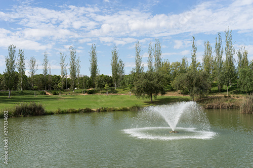 Fototapeta Naklejka Na Ścianę i Meble -  Fountain in a pond. Parque de Cabecera, Valencia, Spain