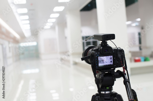 Professional camera on tripod while shooting in room