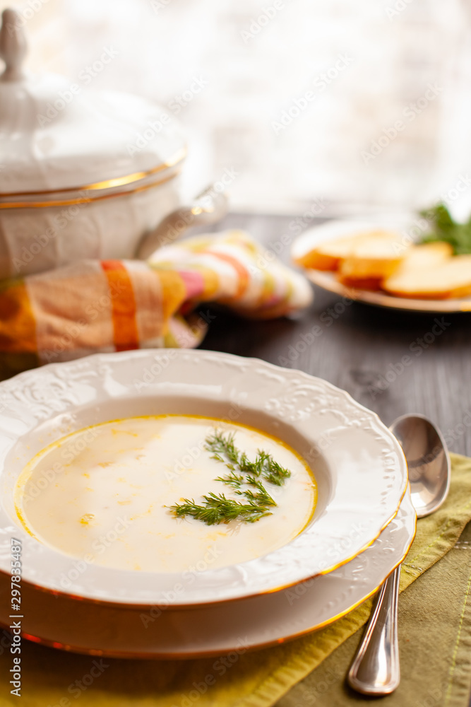 Creamy fish soup with salmon and potatoes on woodwn table