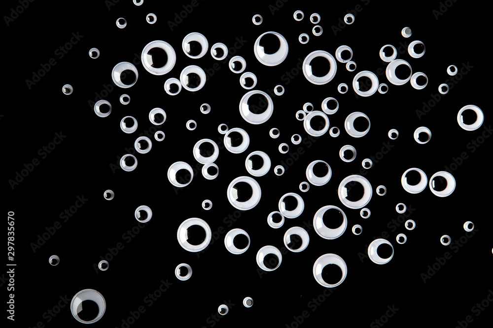 Top view of many googly eyes on black background