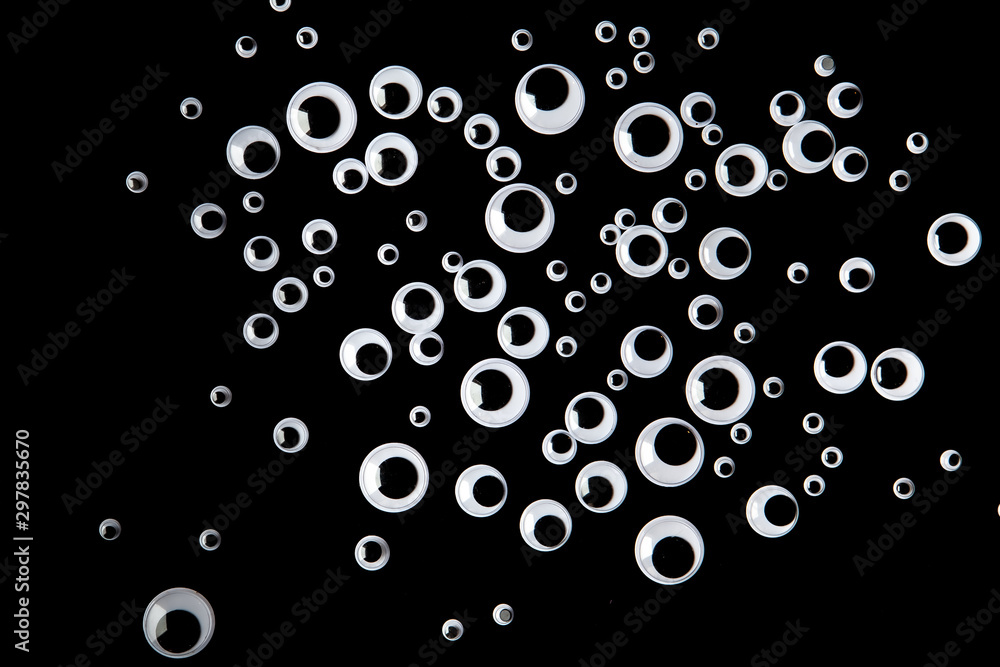Top view of many googly eyes on black background Top view of many googly eyes on black background