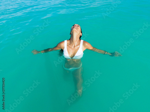 Woman relaxing in turquoise waters of the Caribbean with eyes closed