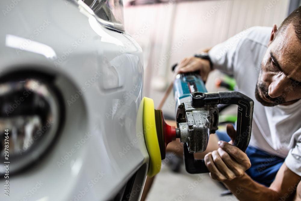 Car detailing - Hands with orbital polisher in auto repair shop. Selective focus. Car detailing - Hands with orbital polisher in auto repair shop. Selective focus.