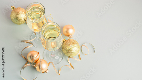 Champagne in glass goblets gold balloons stars serpentine a pastel delicate pink background. New year christmas concept.