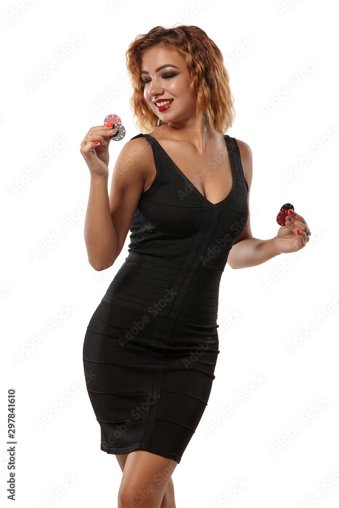 Ginger girl wearing a black dress is posing holding red and green chips in her hands standing isolated on background. Casino, poker. Close-up. Stock-foto | Adobe Stock